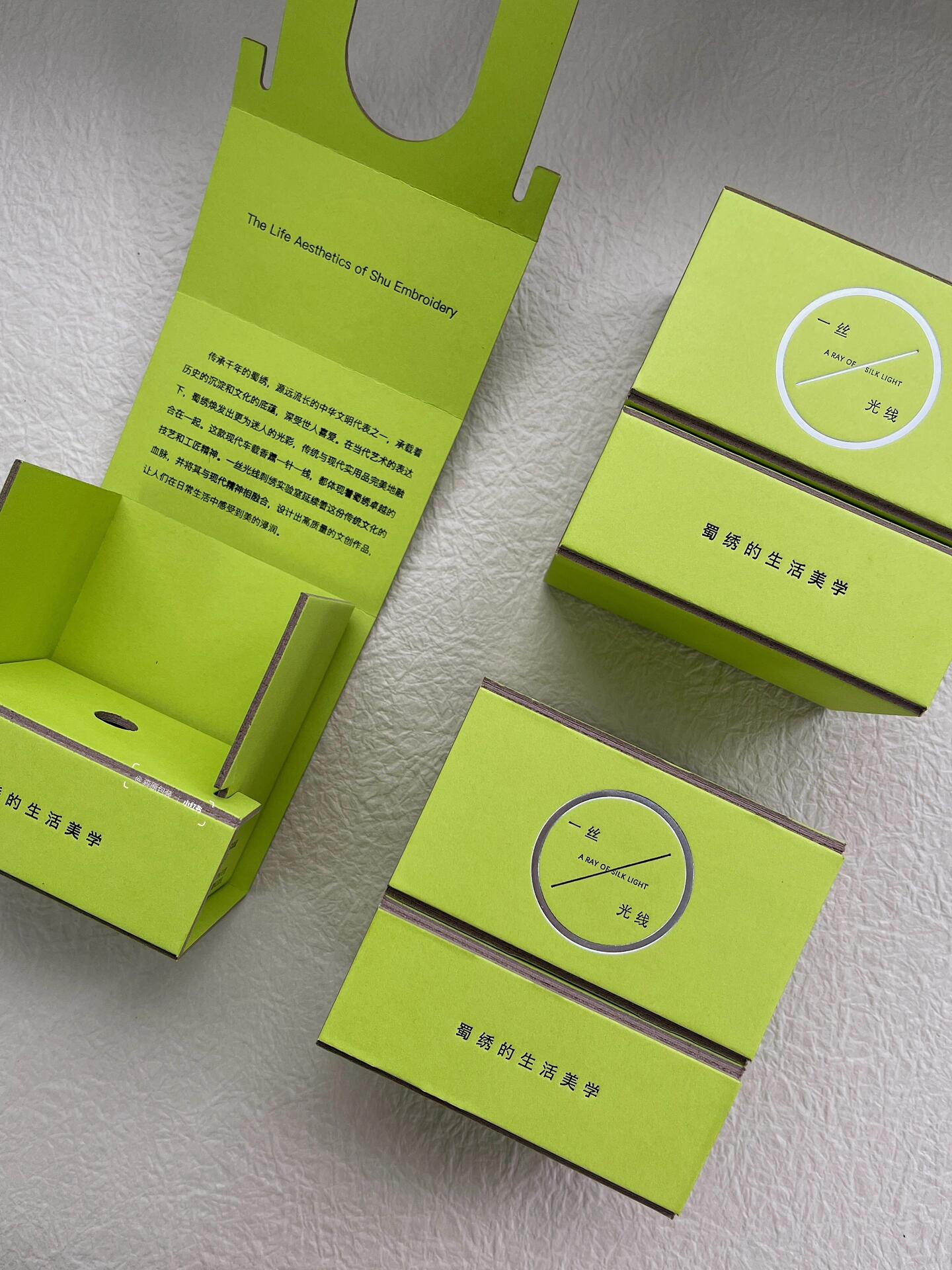 Two-piece folding card box with integrated insert in bright green paper