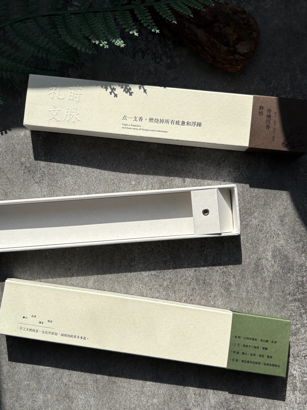Ivory Sliding Incense Box with Paper Tray: close-up of the light paper surface and colorless raised lettering