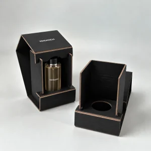 Black 2-piece foldable grayboard perfume box with a bottle seated through the circular locating insert
