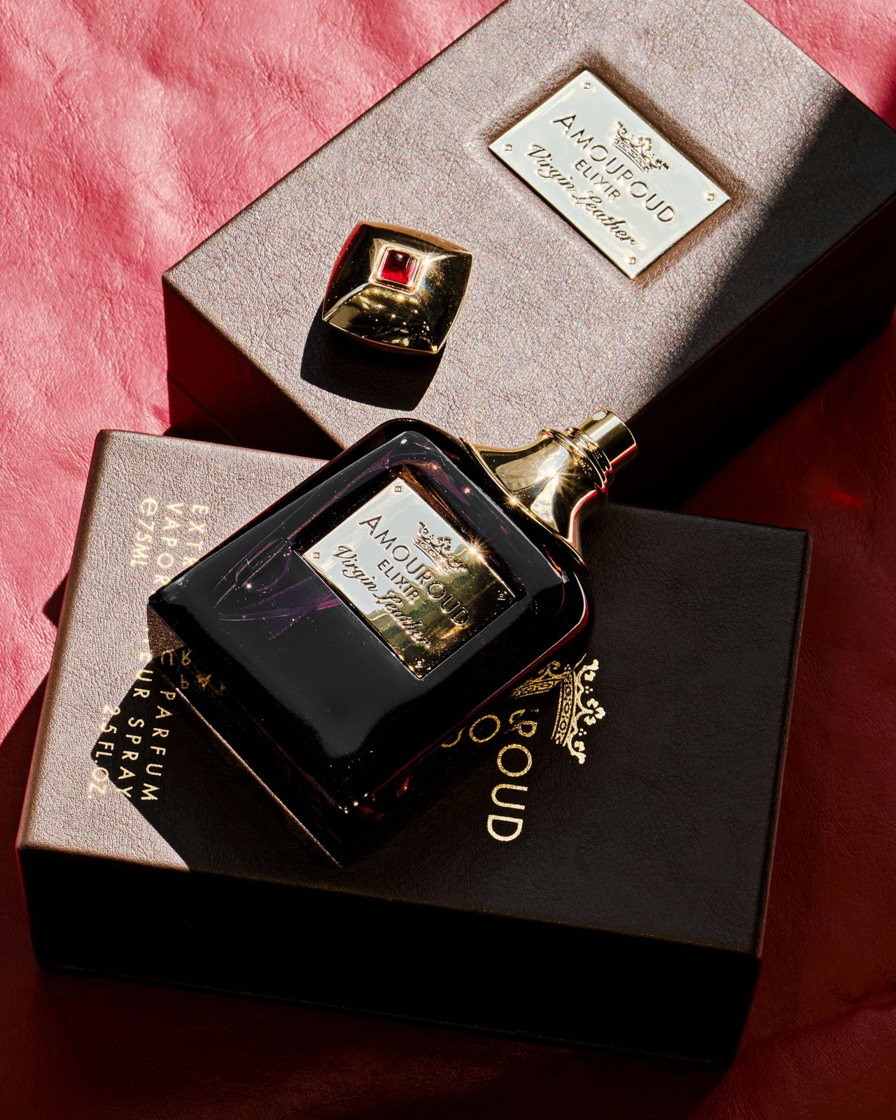 A perfume bottle, separate cap and decorative presentation boxes