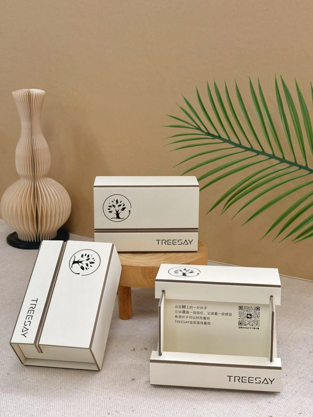 Ivory Board Gift Box with Botanical Logo: closed ivory board-panel box with a dark botanical logo and wordmark