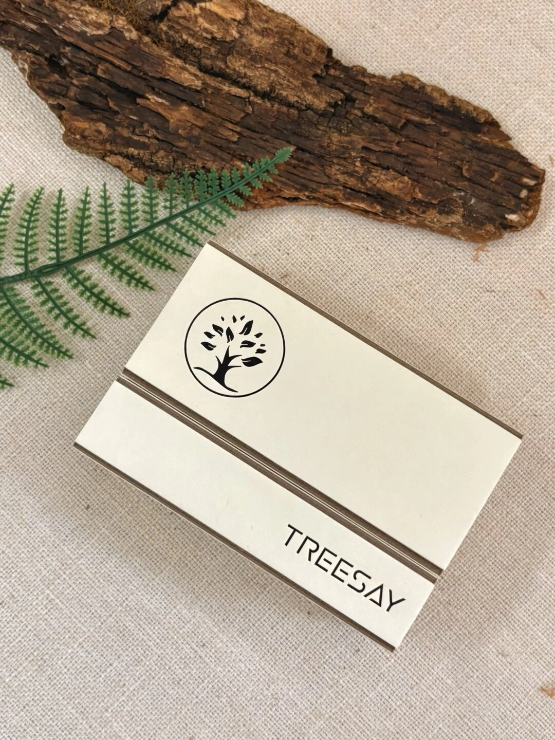 Ivory Board Gift Box with Botanical Logo: close-up of the botanical logo and facing paper