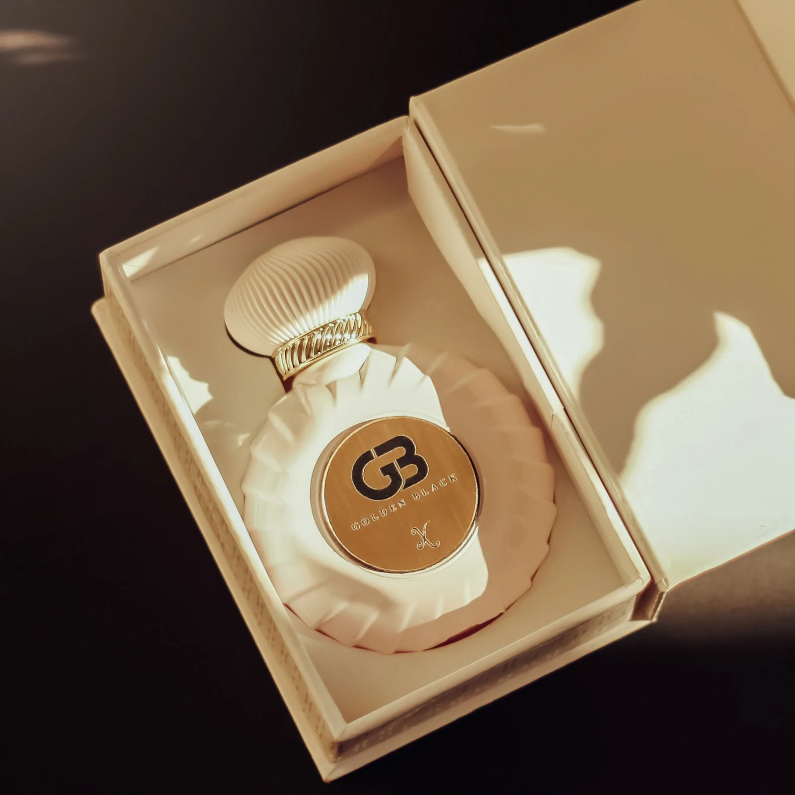 A capped perfume bottle presented inside an open box