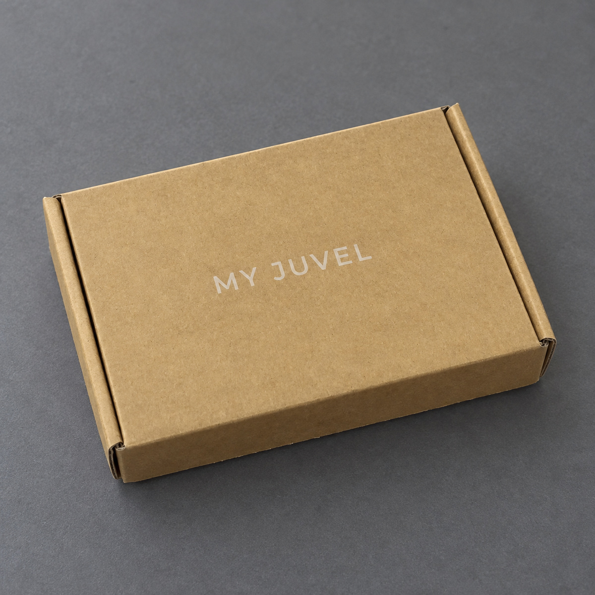 Closed kraft brown mailer box with subtle light-colored printed branding