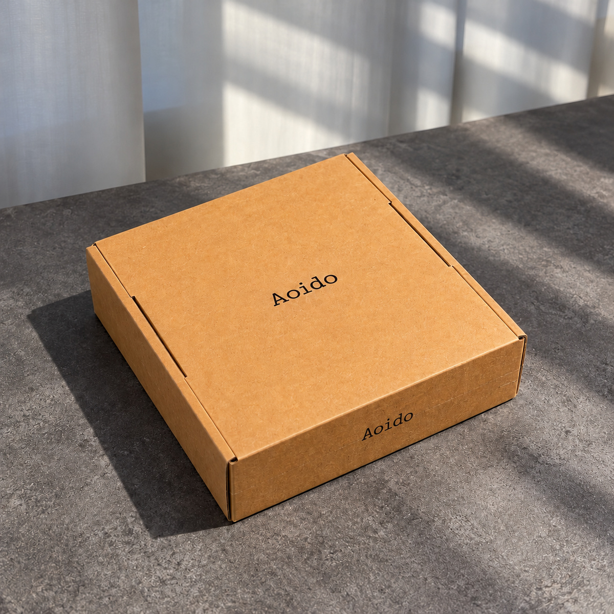 Closed kraft brown tear-strip mailer box with minimal dark logo printing