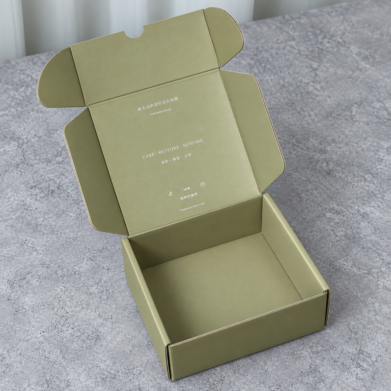 Open olive green mailer box showing the plain interior and printed inner lid