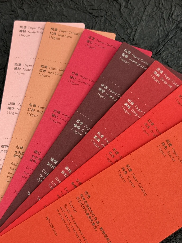 Pink, red and burgundy paper samples with printed color names