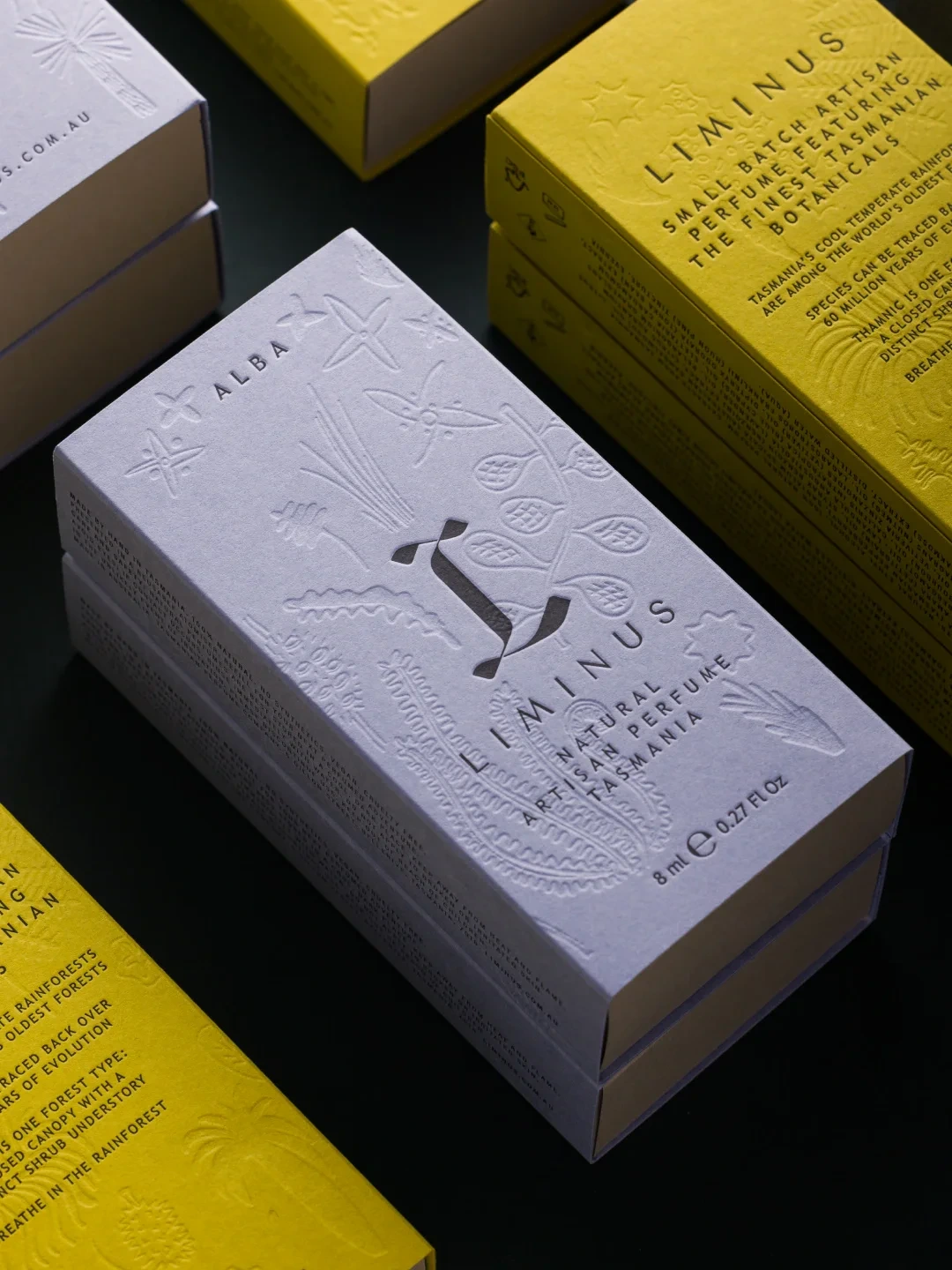 Lavender and yellow perfume cartons with botanical relief and printed lettering