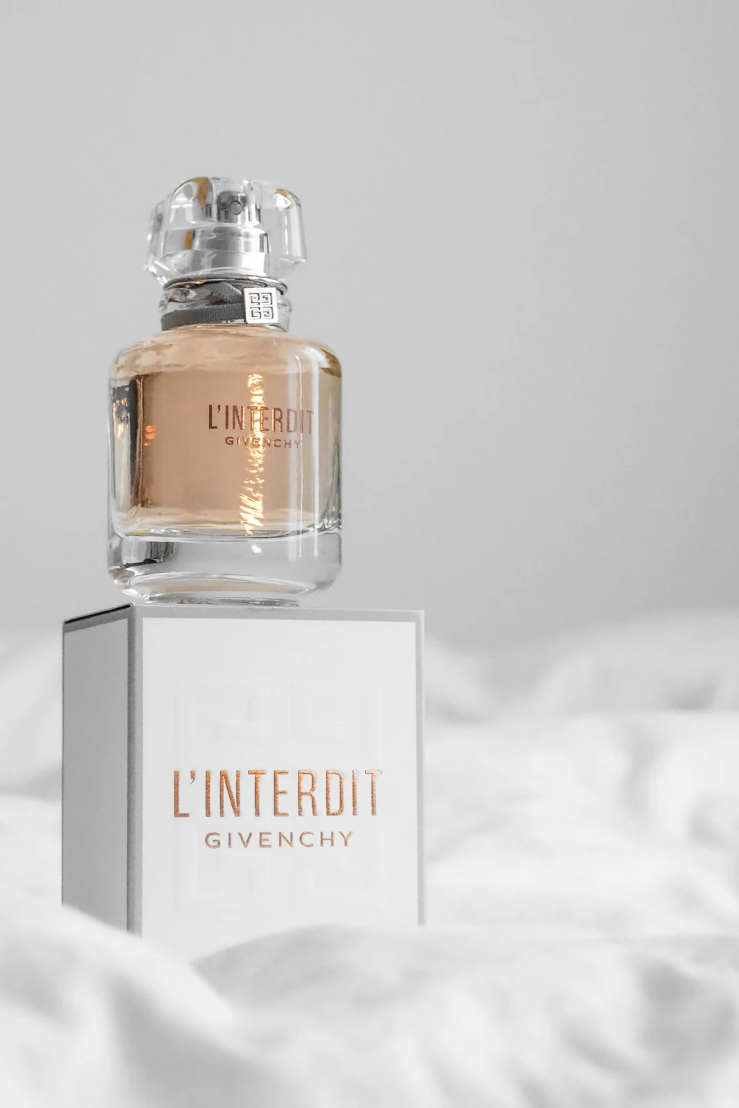 A perfume bottle standing on its matching printed carton