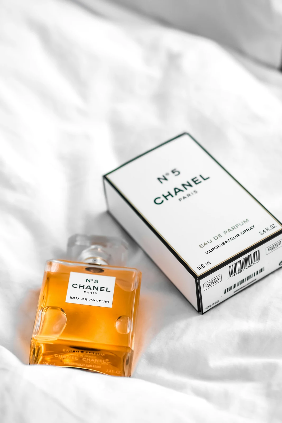 A perfume bottle beside a printed carton with identifying information