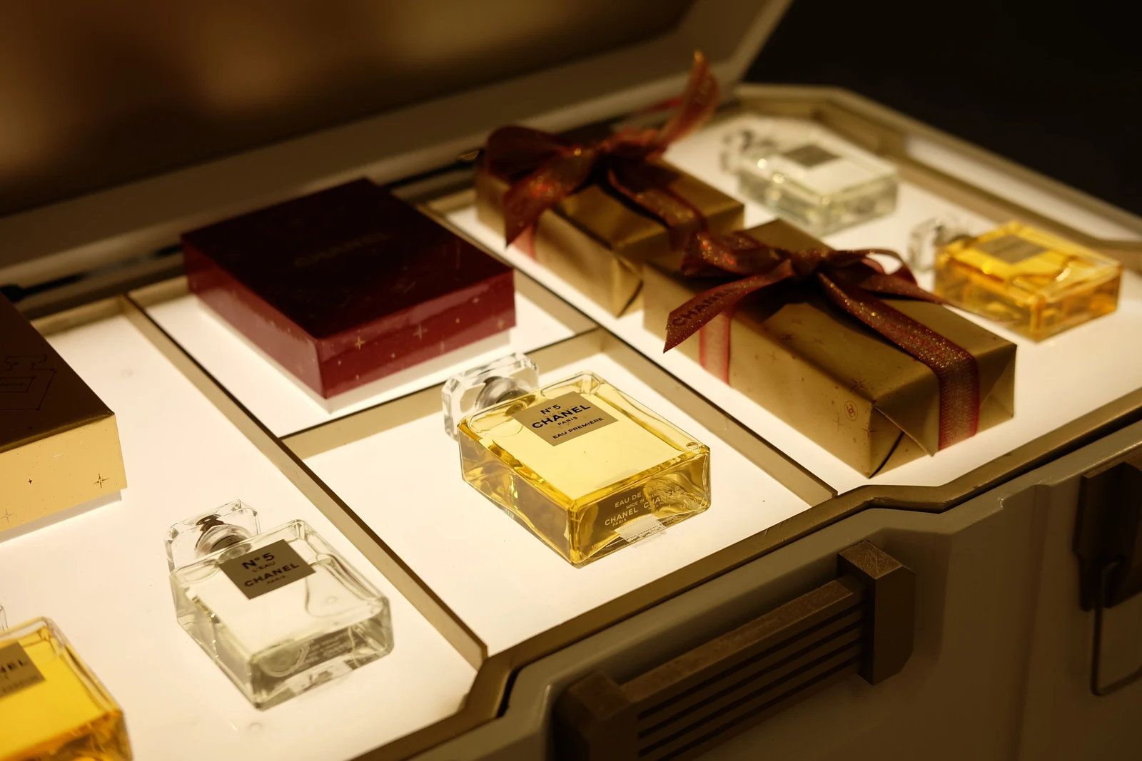 Perfume bottles and ribbon-wrapped gift boxes displayed together