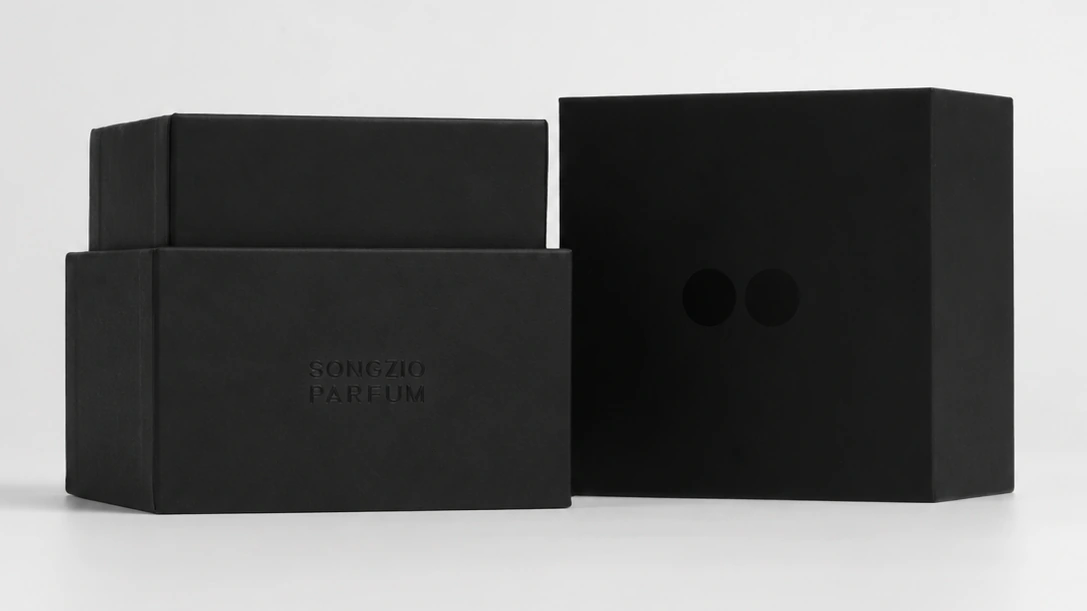 Black perfume boxes with fitted lids and debossed lettering