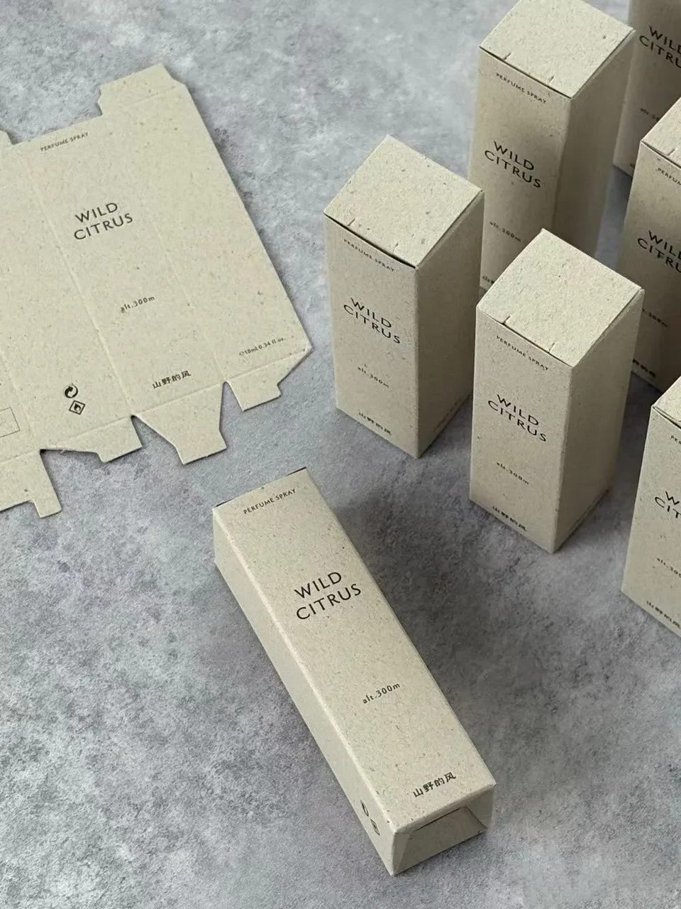 A flat fragrance carton beside assembled boxes