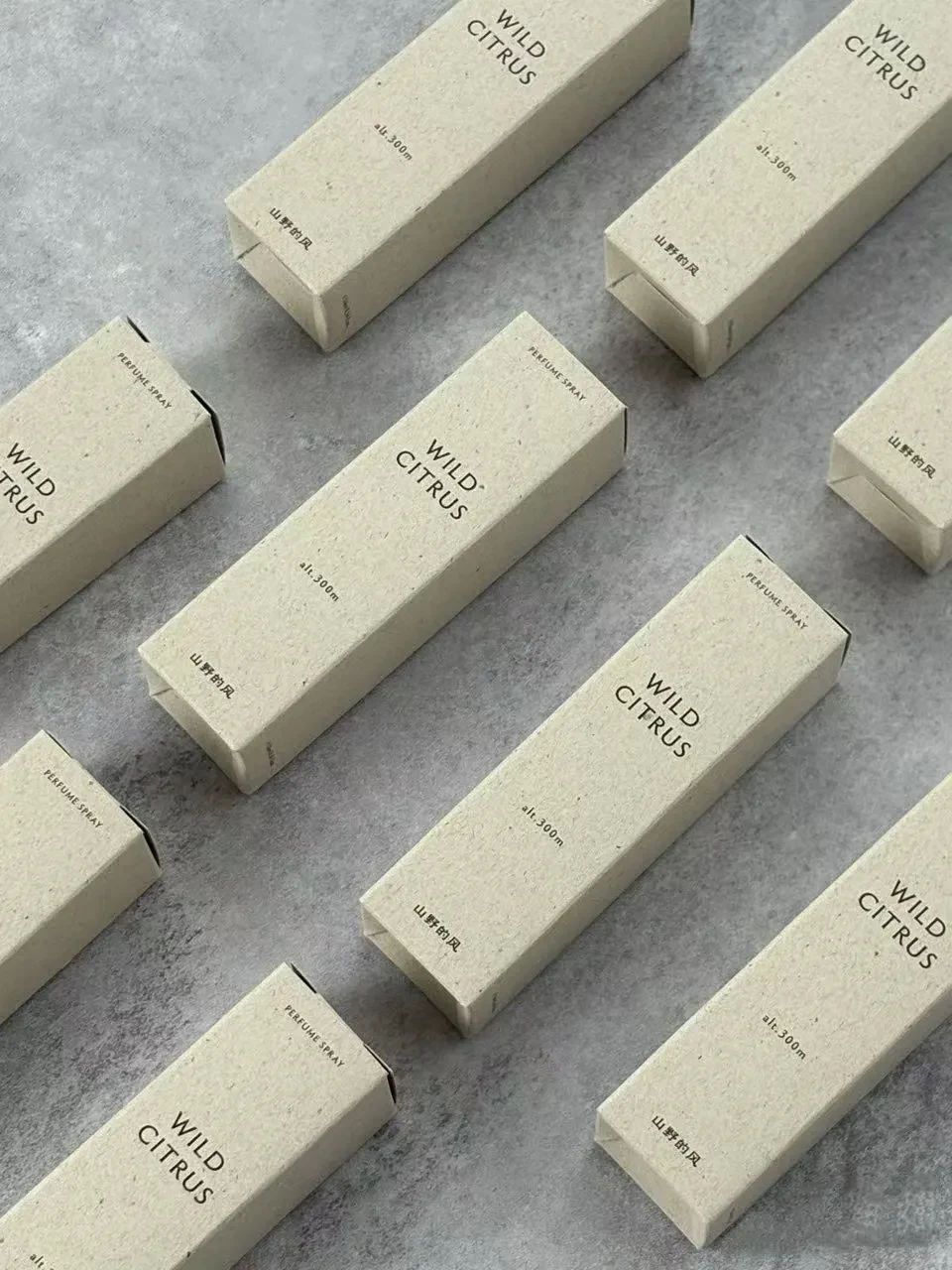 Perfume spray cartons arranged on a grey surface