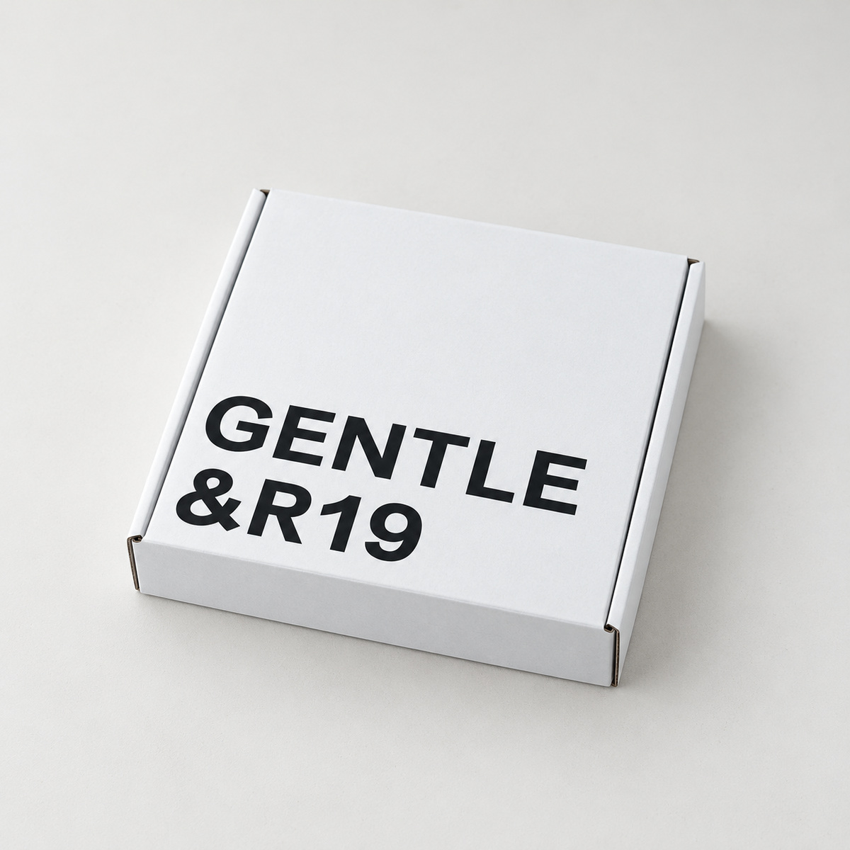 Closed white folding mailer box with bold black logo printing