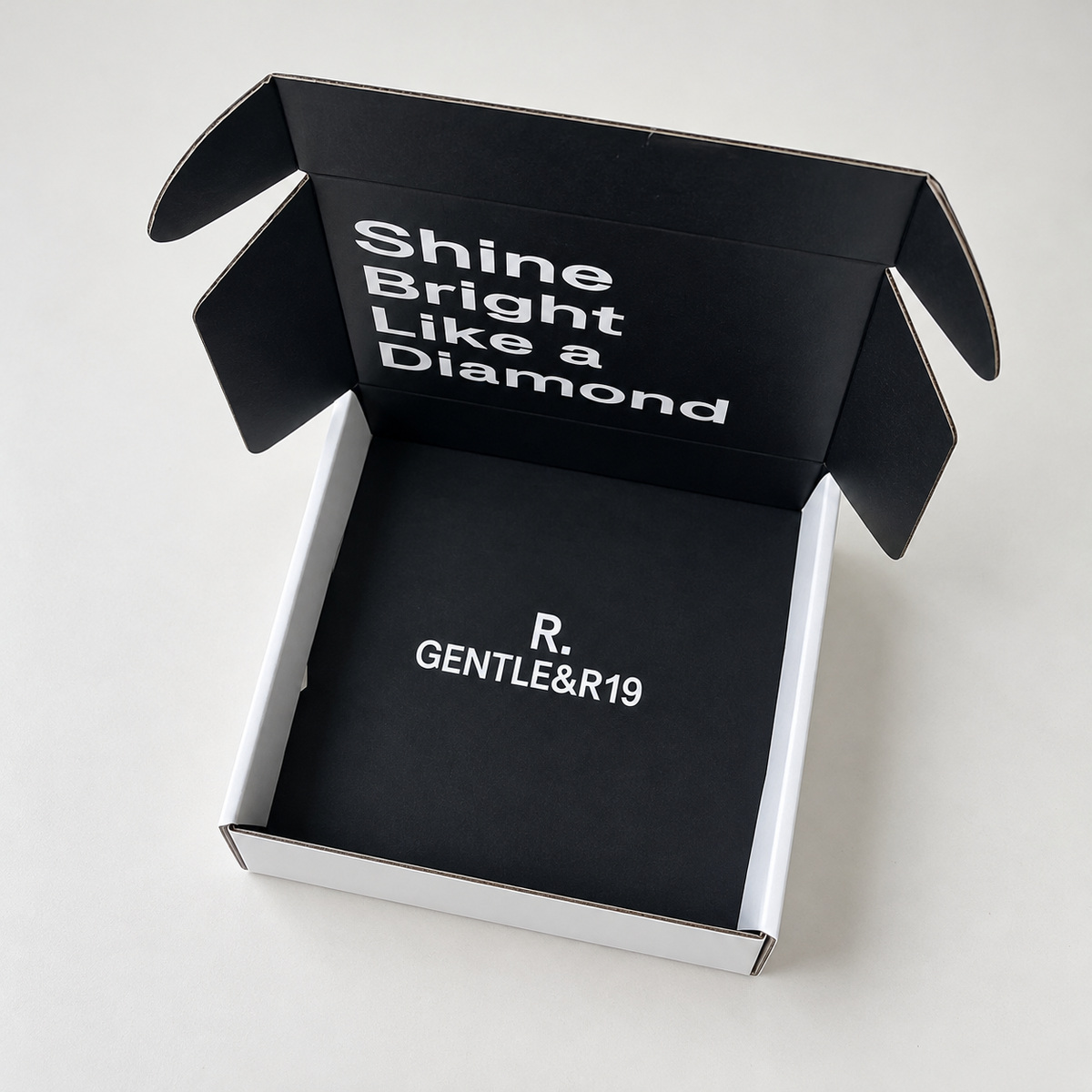 Open white mailer box showing a black interior with contrasting white typography